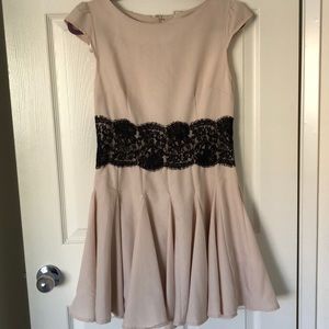 Beige dress with black lace .